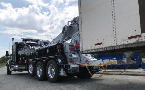 A Vulcan V-100 wrecker towing a heavy trailer with the 5th wheel plate