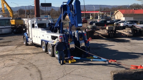 IMage shows a Vulcan v30 wrecker using a 3rd drag winch to roll a loaded container back over.