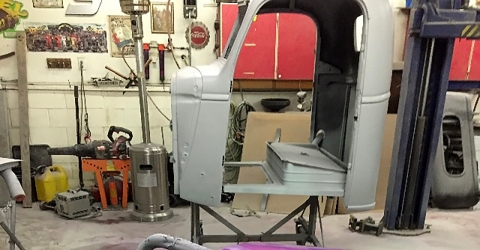 Images of a cab portion of the Holmes 330 junior wrecker on primed and sitting on stands during the restoration