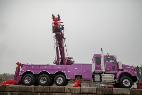 Side view of a western star truck with a purple century 1150 rotator mounted on the back