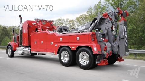 The Vulcan v-100 heavy-duty integrated wrecker driving down the highway.